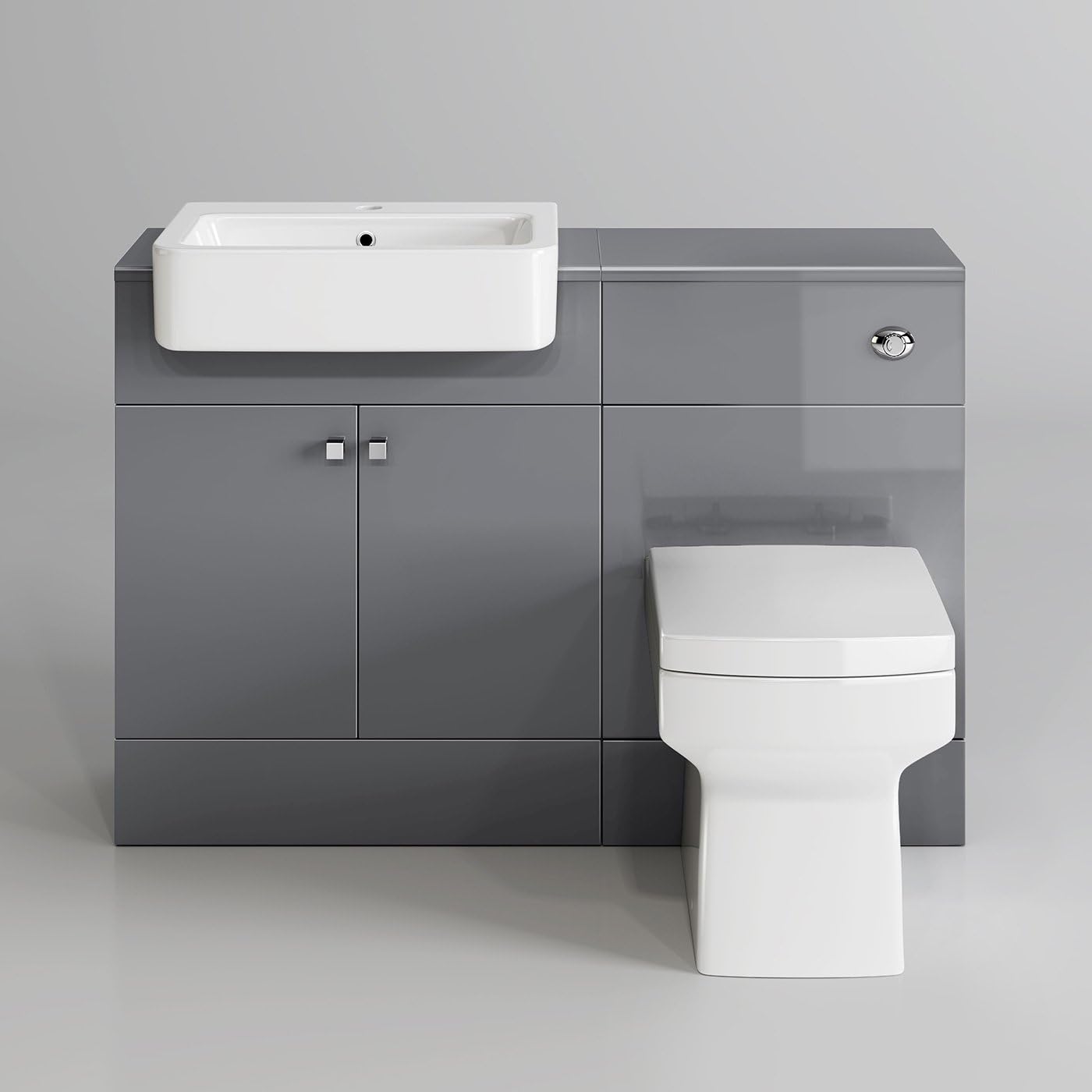 A modern bathroom with a white toilet, sink, and bathtub. The walls are tiled in a light gray color.
